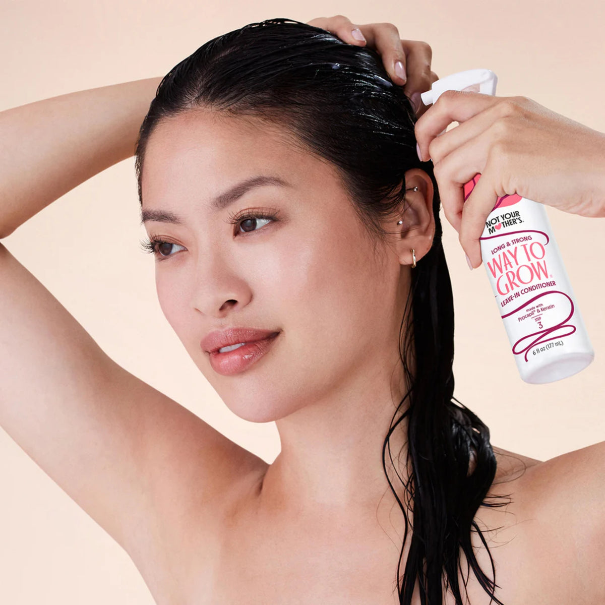 Kvinde med vådt hår sprayer Not Your Mother's Way To Grow leave-in conditioner i håret.
